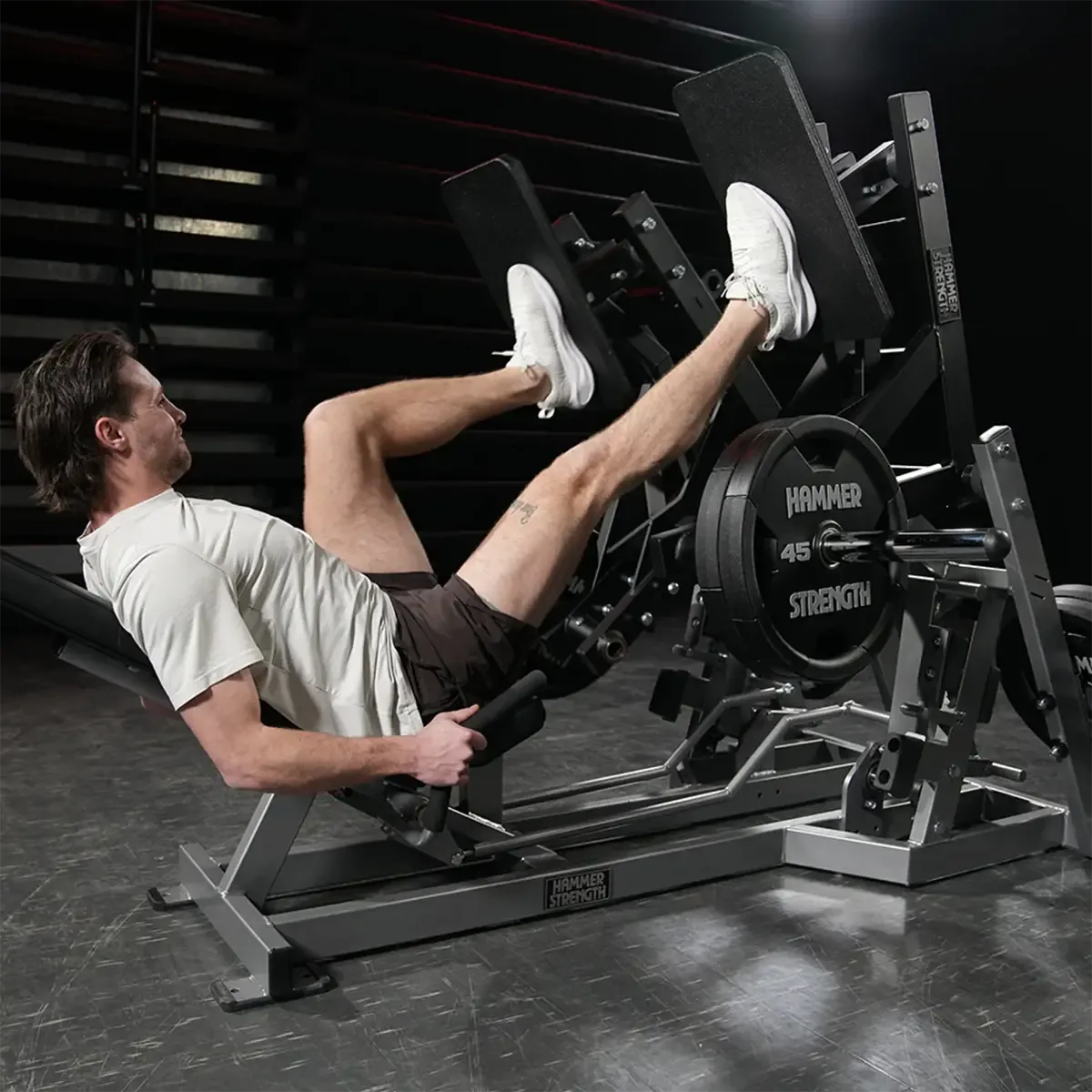 Hammer Strength Plate-loaded squat press with articulating foot platforms and dual-purpose handles