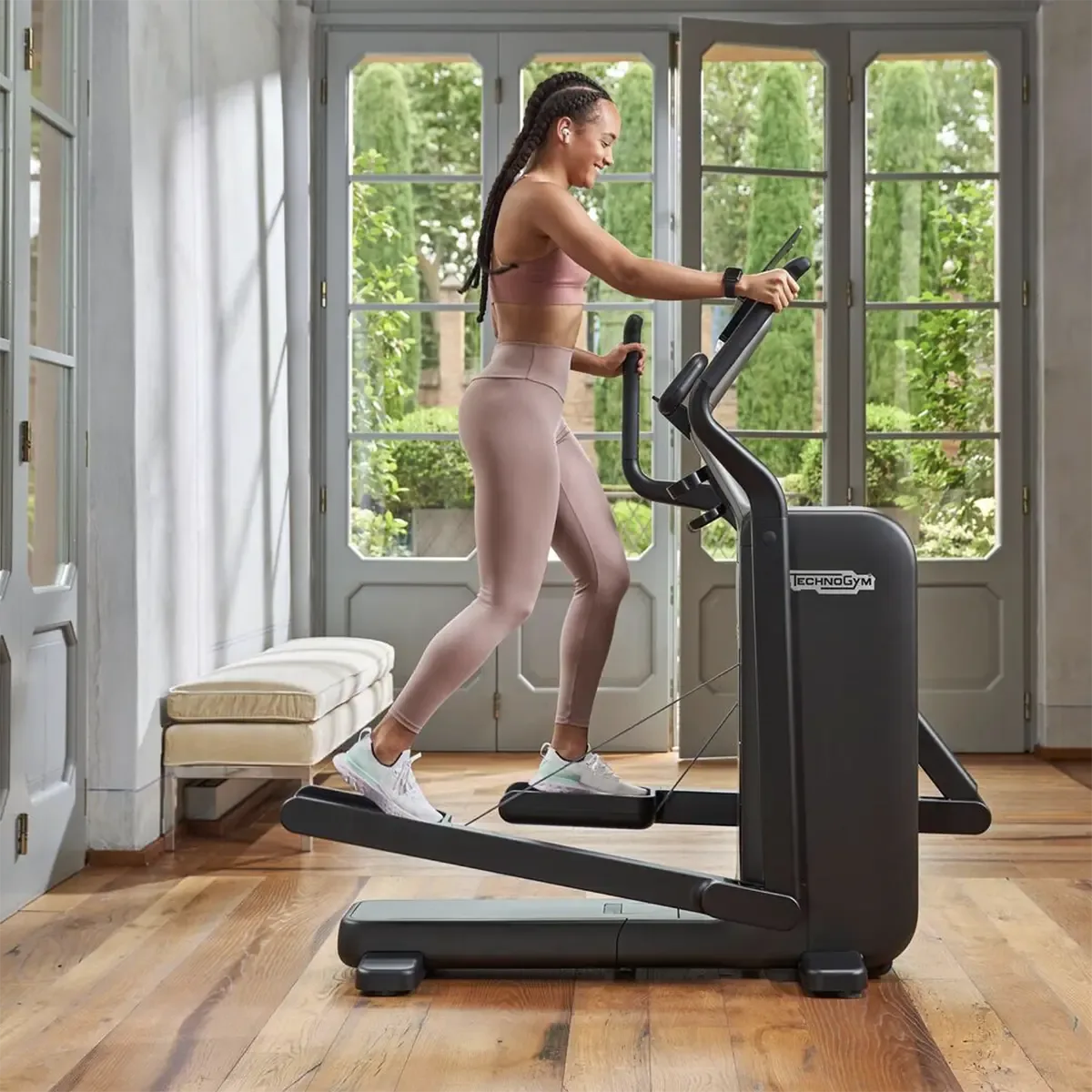 Technogym Compact side view of compact foldable elliptical trainer with device holder
